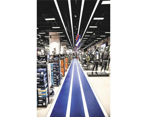 Interiör av en Hornbach-butik med sportartiklar och en blå gångväg