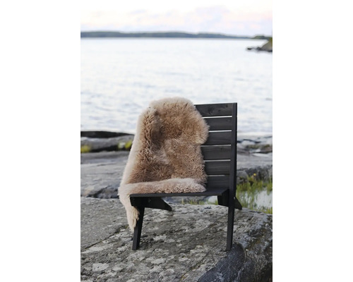 Träbänk med fårskinnsfäll vid sjön