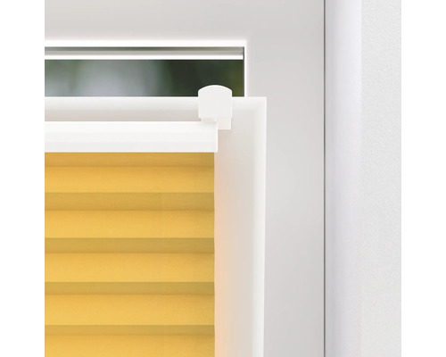 Detaljbild av en gul plisségardin på ett fönster