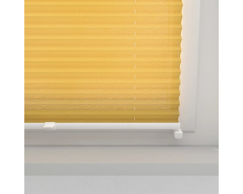 Gul plisségardin vid fönstret