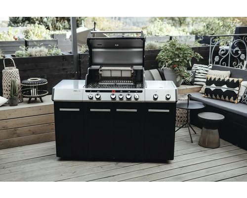 Utekök med öppen grill och svart underskåp på en terrass