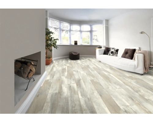 Ljust vardagsrum med trägolv, soffa och öppen spis