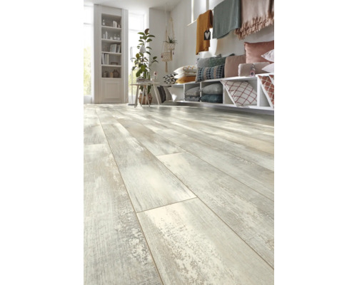 Ljust vardagsrum med laminatgolv i trälook, hyllor, kuddar och dekoration