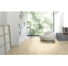 Ljust rum med laminatgolv, fåtölj och dekoration