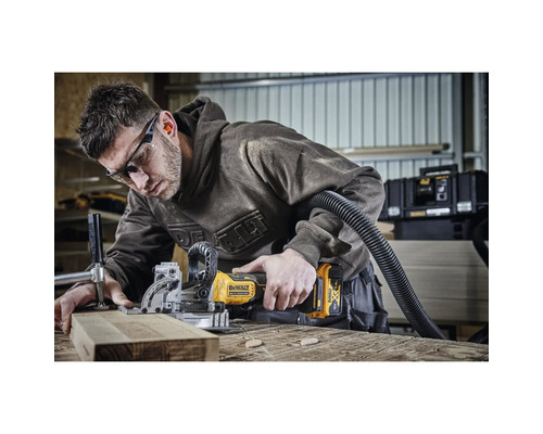 En hantverkare använder en sladdlös notfräs på en träbit i en verkstad