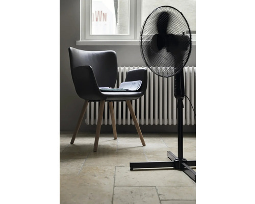 Rumsöversikt med en svart stol, en fläkt och ett element