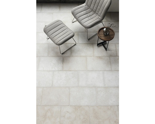 Klinkergolv inomhus med fåtölj och sidobord.