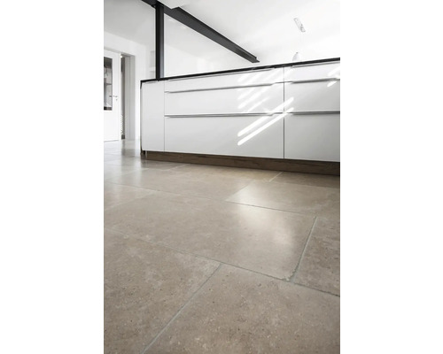 Köksscen med vita skåp och golvplattor.