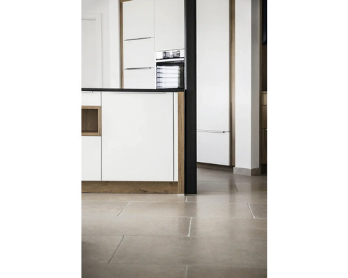 Köksinredning med vita skåp, mörk bänkskiva och stengolv