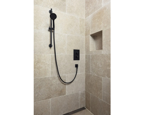 Dusch med svart duschstång, armatur och förvaringsfack