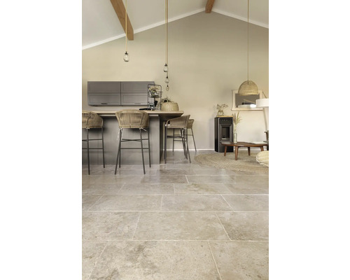 Vardagsrum med golvplattor i naturstenslook, köksö och sittplatser.