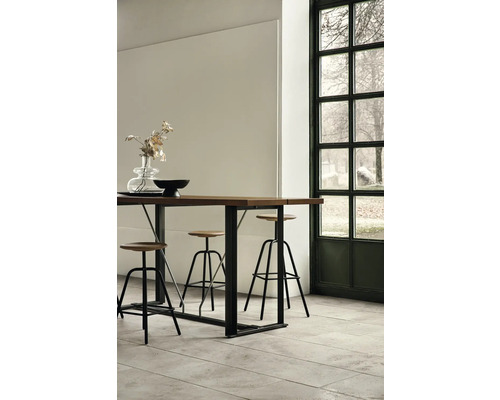 Högt bord med stolar i ljus inredning intill ett fönster