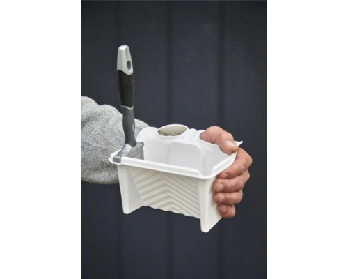 Person som håller en färgburk med pensel