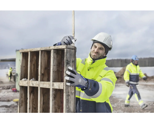 Byggnadsarbetare med arbetshandskar och tumstock på jobbet