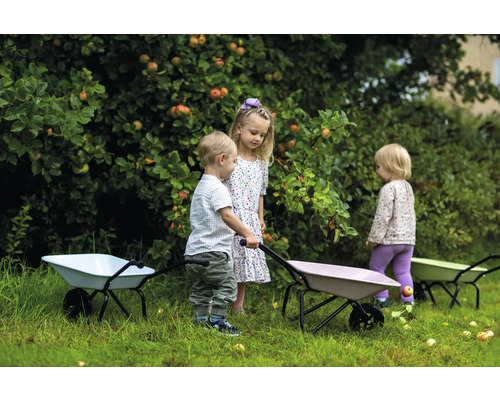 Tre barn med skottkärror i trädgården under ett äppelträd.