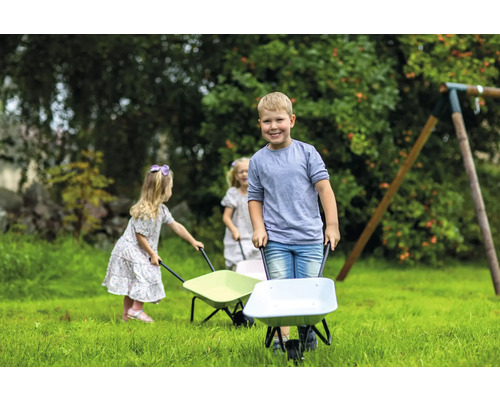 Barn skjuter skottkärror i trädgården