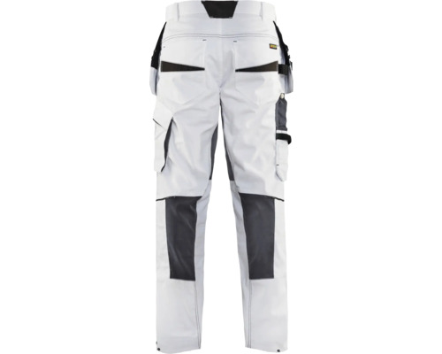 Vita arbetsbyxor med fickor och förstärkta knän bakifrån.