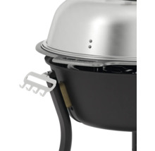 Detaljvy av en klotgrill med silverfärgat lock och redskapshållare