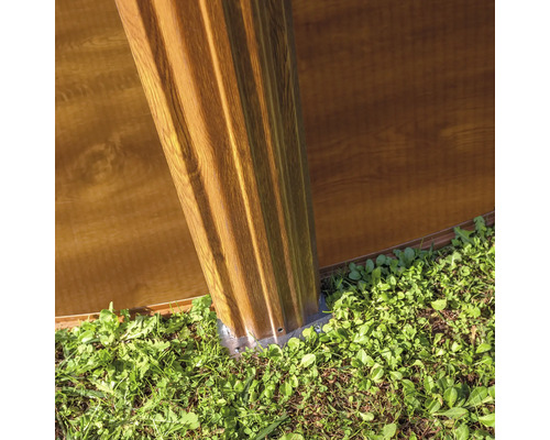 Detalj av ett trädgårdshus med träfasad och grund i trädgården.