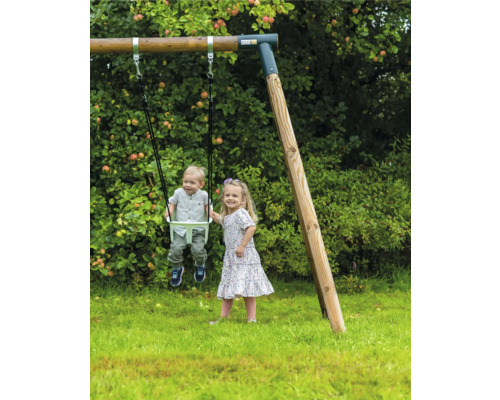 Barn leker på en trägunga i trädgården.