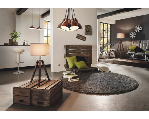 Ljus inredning med pallsoffa, golvlampa och rund matta