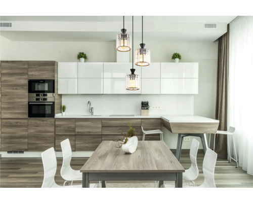 Ljust kök med matbord, stolar och taklampor