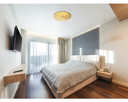 Sovrum med säng, sängbord, TV och taklampa