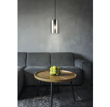 Pendellampa i glas ovanför soffbord med äpplen