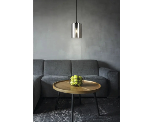 Pendellampa i glas ovanför soffbord med äpplen