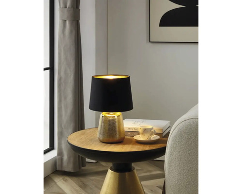 Bordslampa med svart lampskärm på ett runt bord