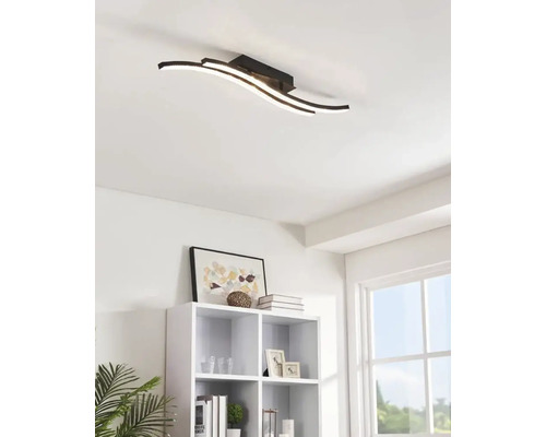 Modern taklampa med böjda LED-ljuselement i ett vardagsrum.