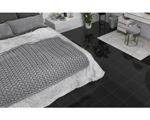 Sovrum och badrum med mörkt golvkakel, säng, byrå och pall