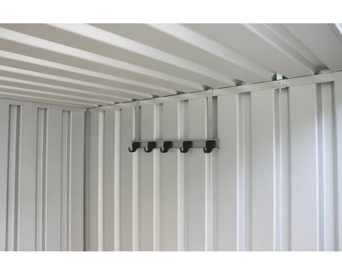 Interiör av ett trädgårdsskjul med väggkrokar för förvaring av trädgårdsredskap