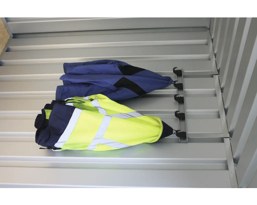 Två arbetsjackor hänger på en garderob på väggen.