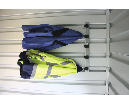 Två arbetsjackor hänger på ett väggskensystem.