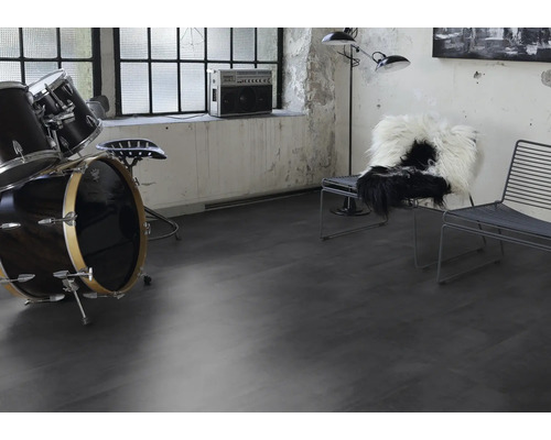 Vardagsrum med trumset, stolar och musikanläggning på mörkt golv