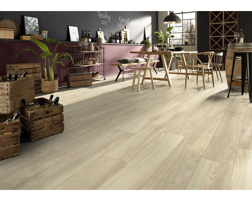 Ljust laminatgolv i ett inre rum med bord och dekorativa element.