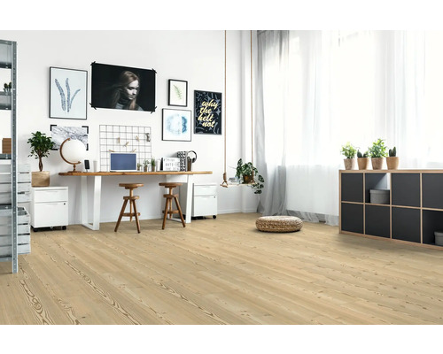 Ljus arbetsplats med trägolv, skrivbord och dekorationer.