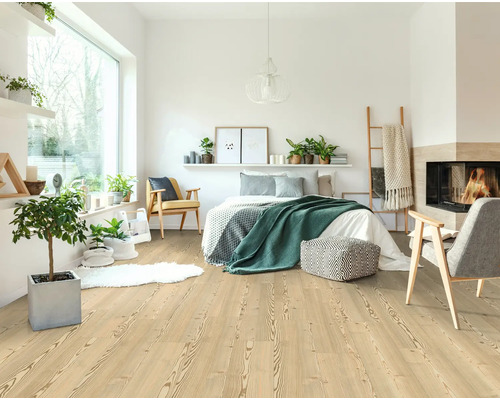 Ljust, vänligt sovrum med trägolv, säng, öppen spis och dekoration