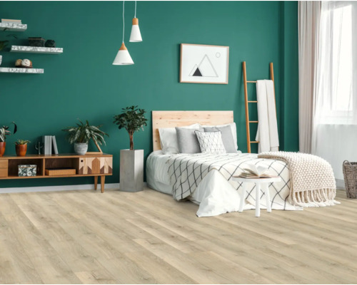 Modernt sovrum med ljust trägolv, säng och dekorationer