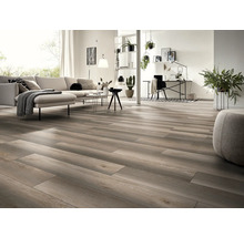 Ljust vardagsrum med trägolv, soffa, bord och arbetsplats