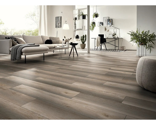 Ljust vardagsrum med trägolv, soffa, bord och arbetsplats