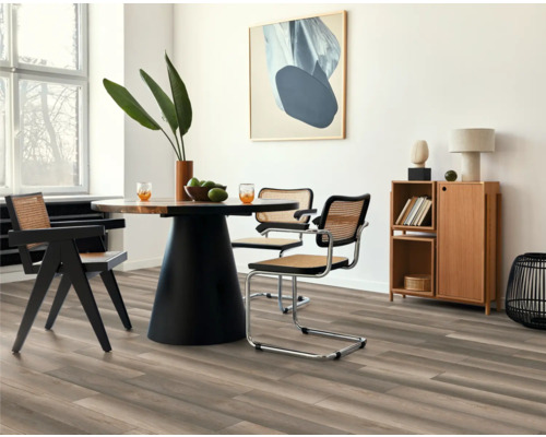 Ljus matsal med trägolv, matbord med stolar och skänk.