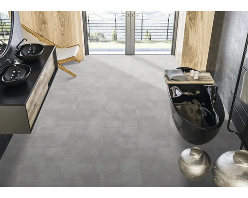 Modernt badrum med grått golv, svart badkar och handfat.