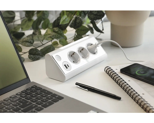 Grenuttag med USB-portar på ett skrivbord med bärbar dator och smartphone