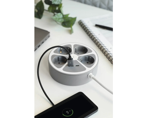 Runt grenuttag med flera portar och anslutna enheter på ett bord.