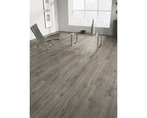 Vardagsrum med laminatgolv i trälook, stol och bord