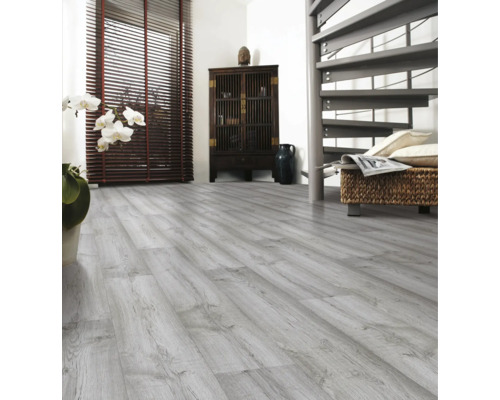 Ljust rum med laminatgolv i trälook, skåp, spiraltrappa och fönster med persienner.