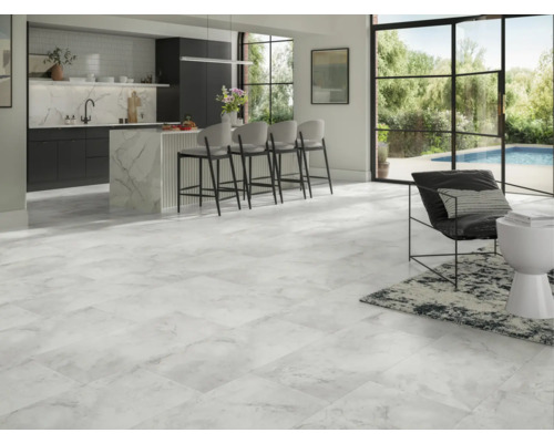 Ljust vardagsrum med marmorplattor, köksö och sittplatser