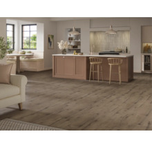 Ljust vardagsrum med trägolv, köksö och sittplatser vid fönstret